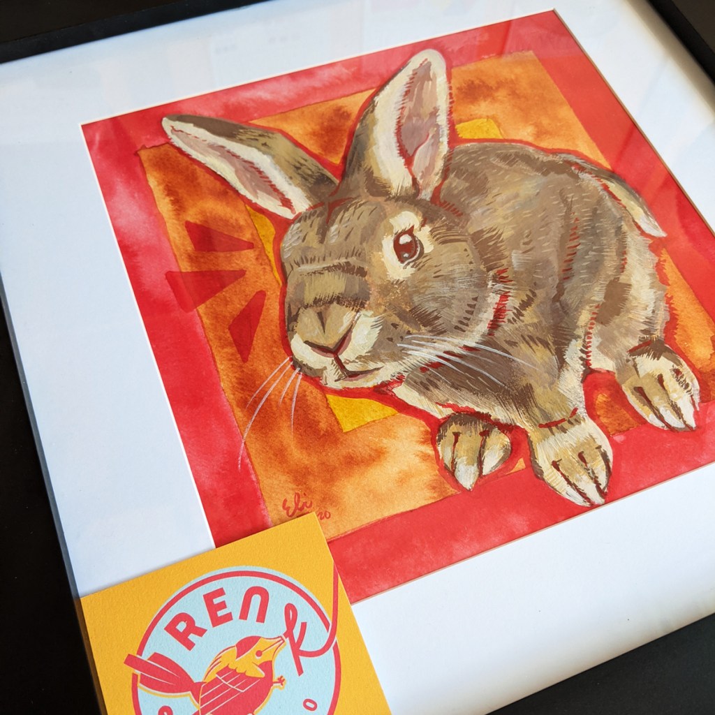 Portrait of a painted bunny in a frame with a yellow business card from Ren S.K. Studio