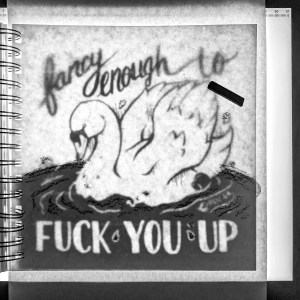 Using charcoal to get textured lines on a light box, covering the swan design with another piece of watercolor paper, charcoal in the top right.