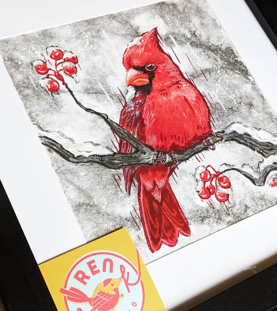 framed portrait of a northern cardinal painted in gouache and sumi ink, yellow Ren S.K. Studio business card in the bottom corner.