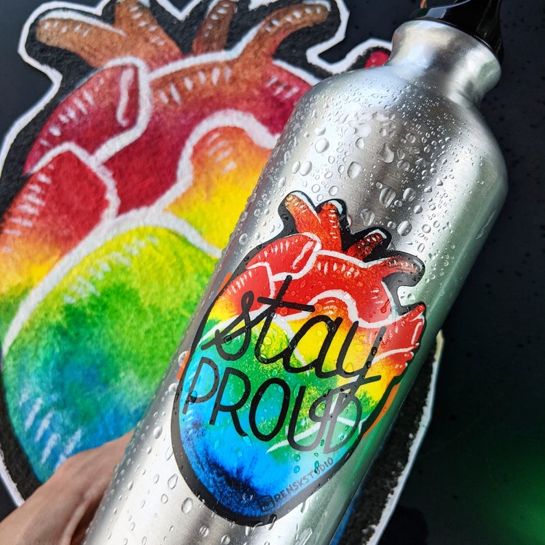 Pride rainbow sticker on a water bottle, heart shaped that say "Stay Proud"
